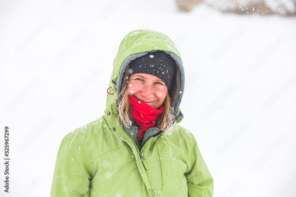 Obraz premium girl with hoarfrosted hair in green jacket grey hat and with red scarf in Caucasus mountains