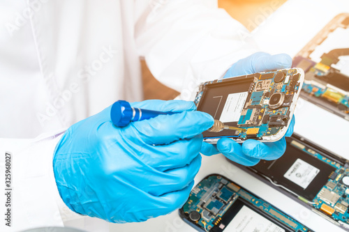 Canvas Print Electronic technician repair faulty mobile phone in electronic smartphone techno