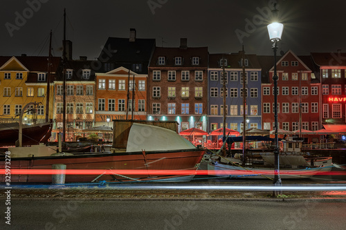 Famous Nyhavn pier with colorful buildings and boats in Denmark, Copenhagen, capital of Denmark. City center and the district of Nyhavn near the canals. Night time, Longexposure photo