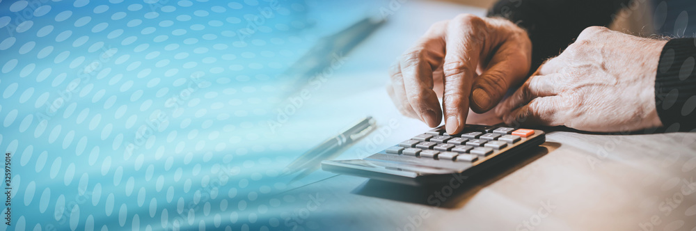 Male hand using a calculator; panoramic banner Male hand using a calculator; panoramic banner