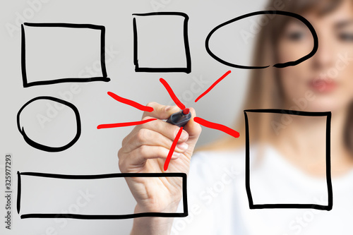 Young woman holds a blue marker and writes something on a light background. Banner. Concept business, company, work, business strategy