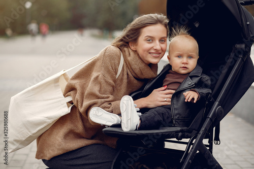 Mother with son. Woman use the carriages. Family in a autumn city