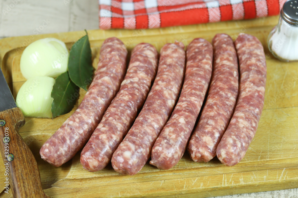 saucisse de Toulouse crues sur une planche à découper saucisse de Toulouse crues sur une planche à découper