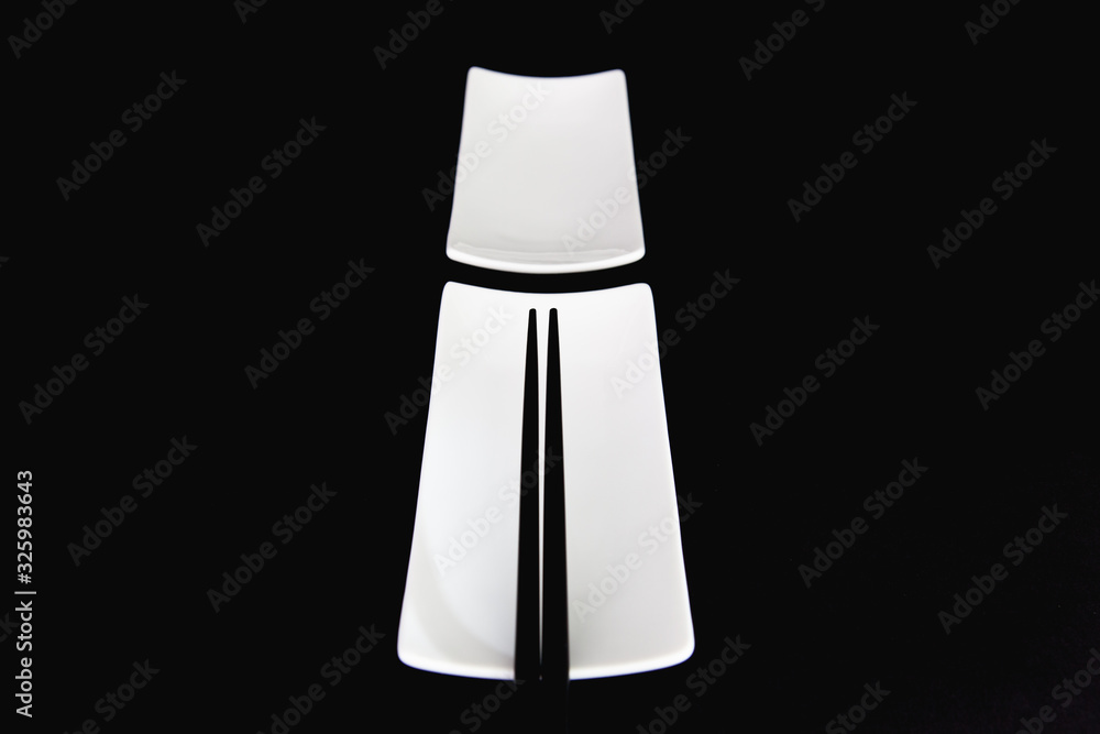White Empty Sushi Plates With Black Bamboo Chopsticks. White Empty Sushi Plates With Black Bamboo Chopsticks.