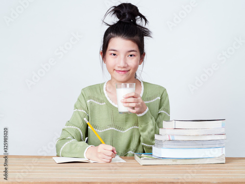 Students drink milk while doing homework.