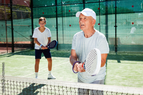 padel players of different generations playing padel court