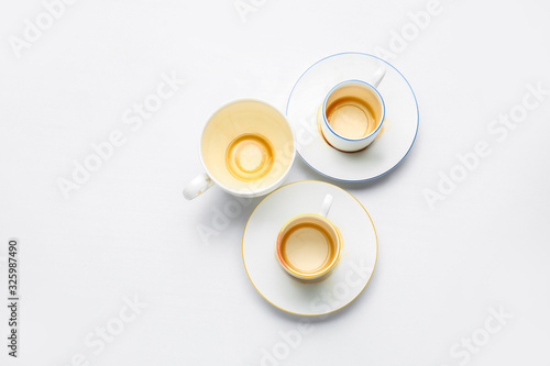 Dirty empty cups with saucers on white background