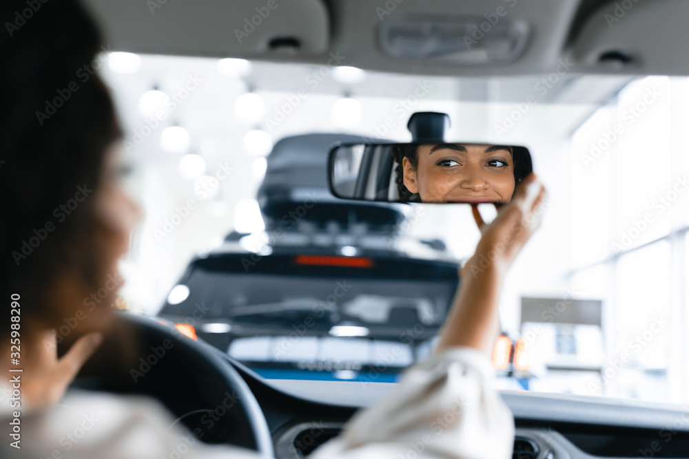 Girl Checking Mirrors Sitting In Driver's Seat In Dealership Store Girl Checking Mirrors Sitting In Driver's Seat In Dealership Store