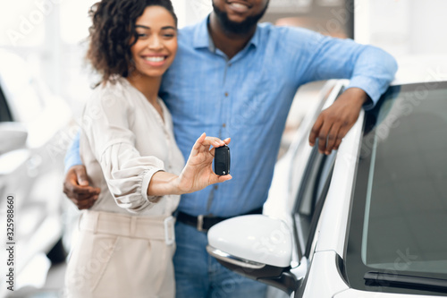 Couple Showing New Auto Key Standing In Dealership Store, Cropped