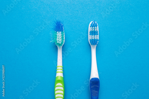 Used old and new toothbrush on a blue background.