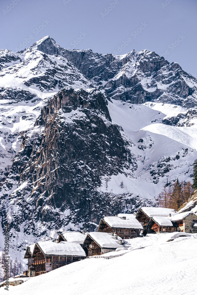 Φωτογραφία The traditional architecture of the Walser villages in the valleys of Monte Rosa, during a fantastic winter day, near the town of Alagna, Italy - February 2020