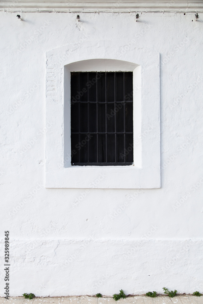 black window on white wall of a house