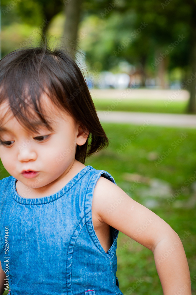 Asian 1 year old toddler is busy playing in a tropical park in the morning. Asian 1 year old toddler is busy playing in a tropical park in the morning.