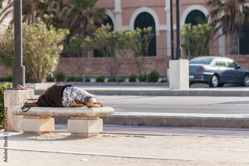 woman sleeping on a public bench