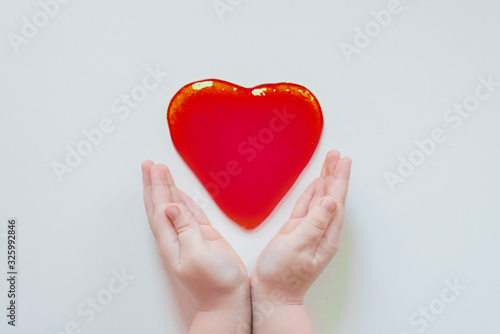 Slime heart in the hands. Sticky mucus in the hand. The child wrinkles the mucus in his hands. Favorite toy for a child. DIY starch is a soft, touch-friendly anti-stress trainer.