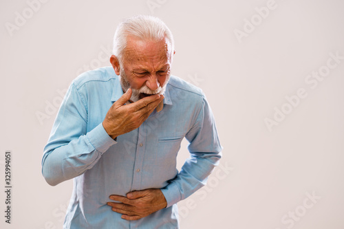 Fotografija Portrait of senior man who is having pain in stomach.