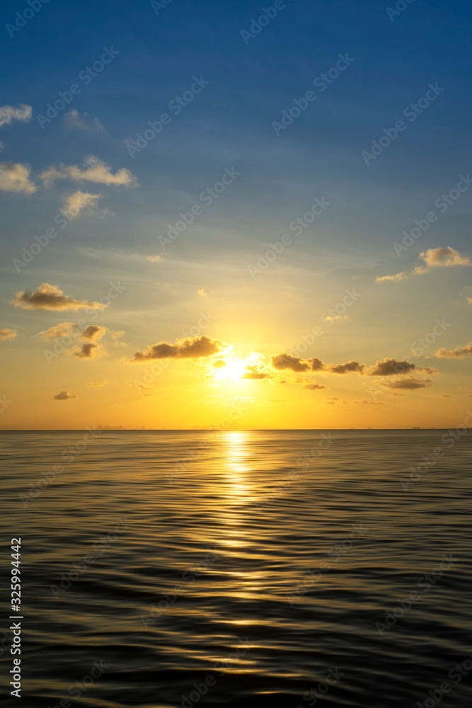 Vertical image of Sunrise at the lake with cloud and small sun