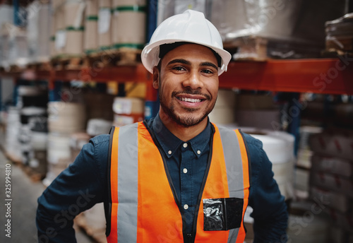 Tablou canvas Smiling warehouse manager in safety vest and hard hat