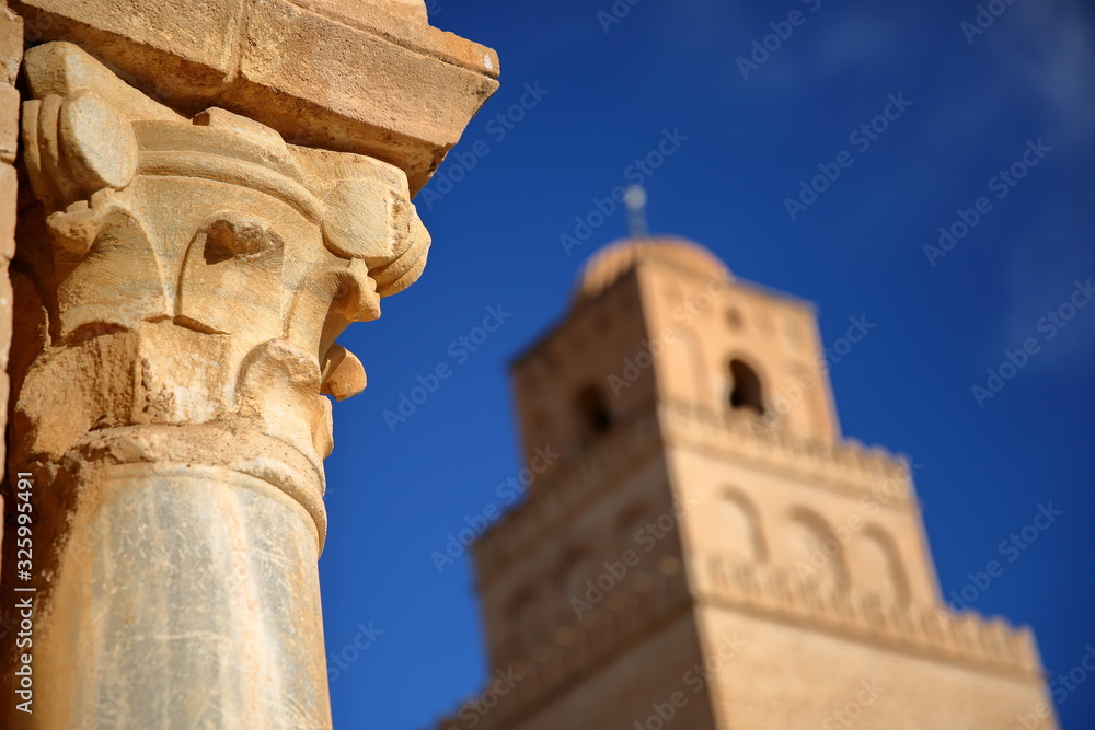 Close-up on a column in the courtyard of  the Great Mosque of Kairouan, Tunisia, with the minaret in the background