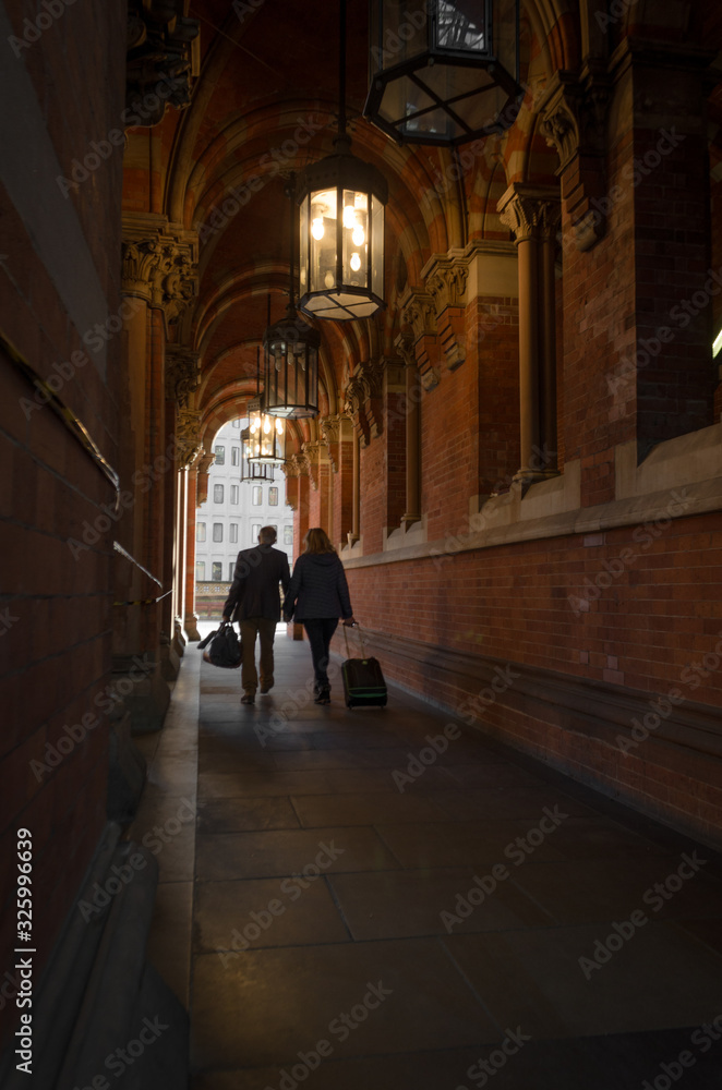 Couple in love walking through a corridor with their suitcases after a trip