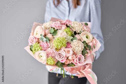 Fototapeta Naklejka Na Ścianę i Meble -  European floral shop. Beautiful bouquet of mixed flowers in womans hands. the work of the florist at a flower shop. Delivery fresh cut flower.