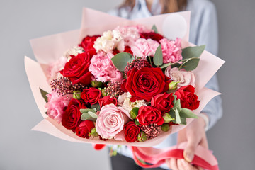 European floral shop. Beautiful bouquet of mixed flowers in womans hands. the work of the florist at a flower shop. Delivery fresh cut flower.