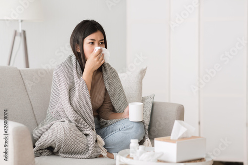 Quadro em tela Cold and flu. Sick girl with runny nose drinking hot tea