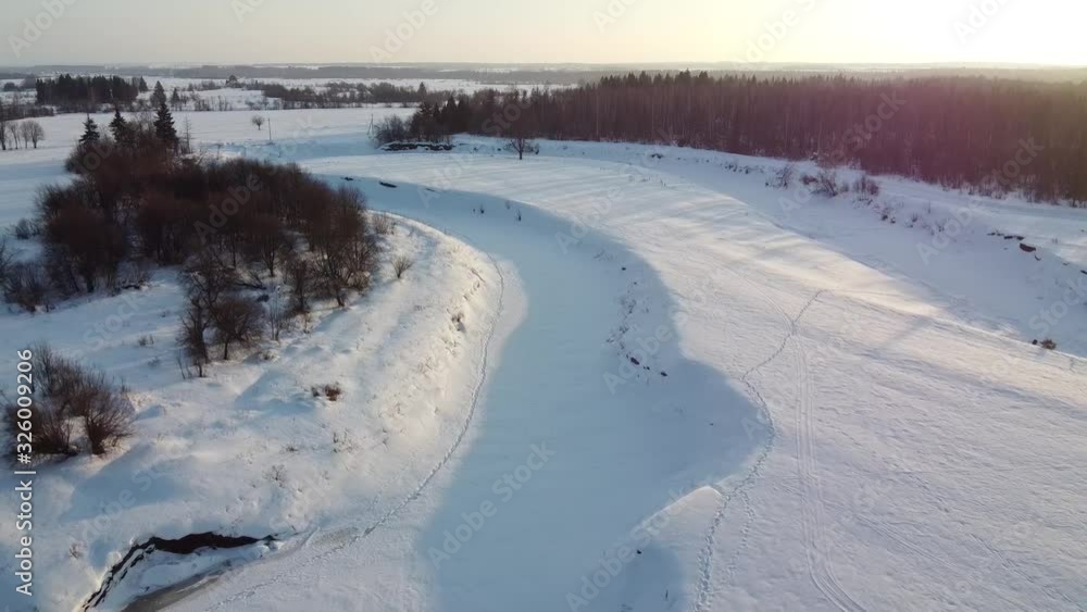 Top view of the snowy fields and forest. Quadrocopter shooting at sunset Top view of the snowy fields and forest. Quadrocopter shooting at sunset