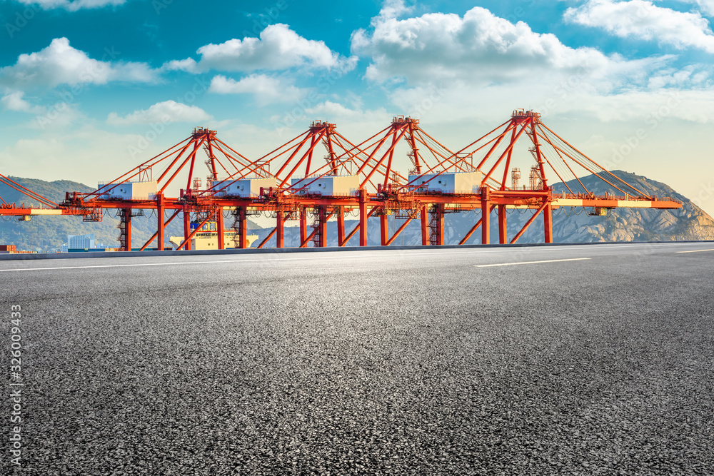 Fototapeta premium Empty asphalt highway and industrial container freight port in Shanghai.