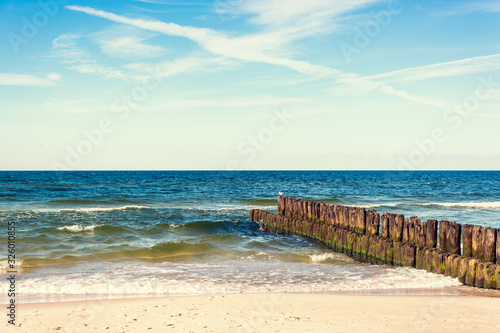 calming view of horizontal line of sea breakwaters and beach
