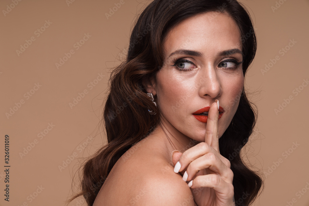 Beauty portrait of brunette adult half-naked woman going shh gesture Beauty portrait of brunette adult half-naked woman going shh gesture