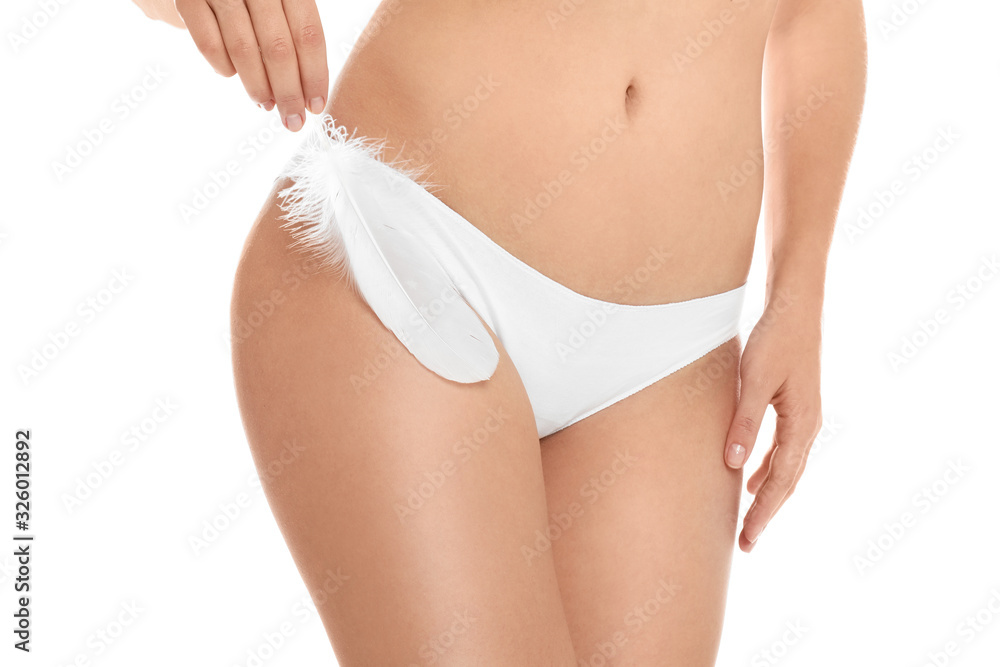 Woman with feather showing smooth skin on white background, closeup. Brazilian bikini epilation - obrazy, fototapety, plakaty 