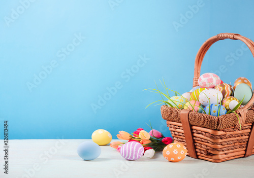 Happy easter, Easter painted eggs in the basket on wooden rustic table for your decoration in holiday. copy space.