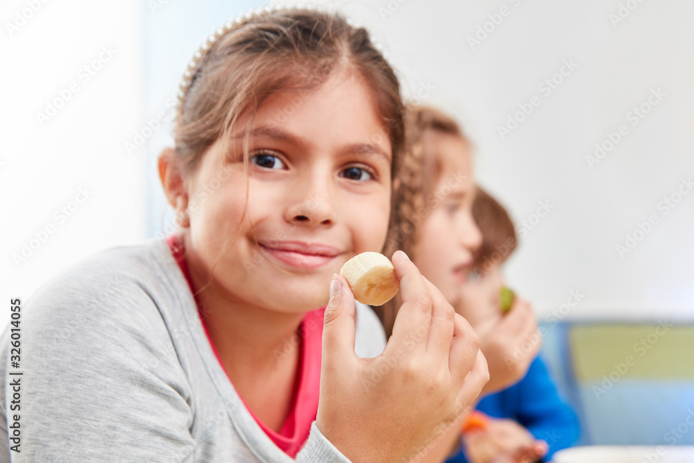 Schülerin isst eine Banane als gesunden Snack Schülerin isst eine Banane als gesunden Snack
