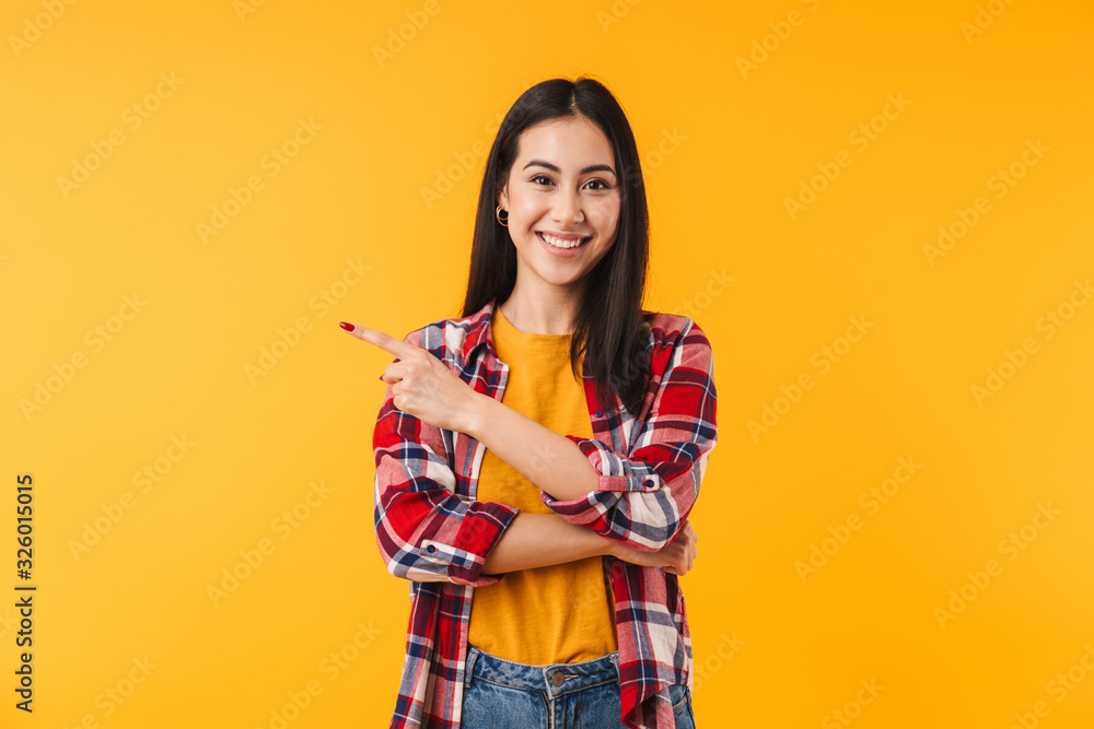 Image of happy attractive woman smiling and pointing finger aside Image of happy attractive woman smiling and pointing finger aside