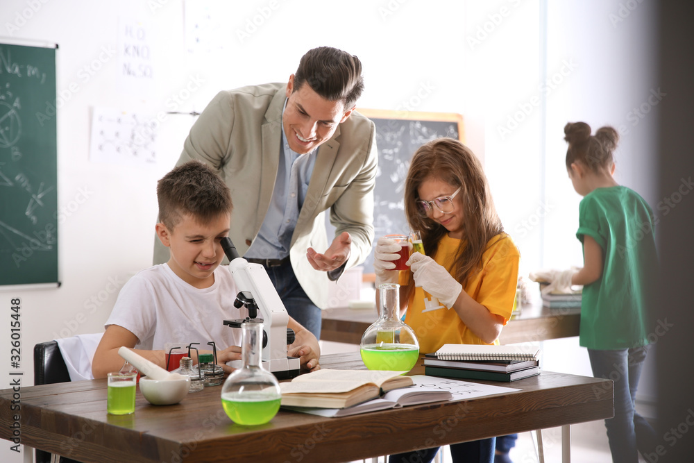 Teacher with pupils at chemistry lesson in classroom Teacher with pupils at chemistry lesson in classroom
