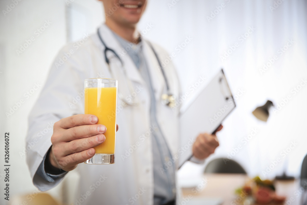 Nutritionist with glass of juice in office, closeup Nutritionist with glass of juice in office, closeup