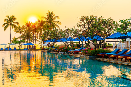 palm tree with umbrella chair pool in luxury hotel resort at sunrise times © topntp
