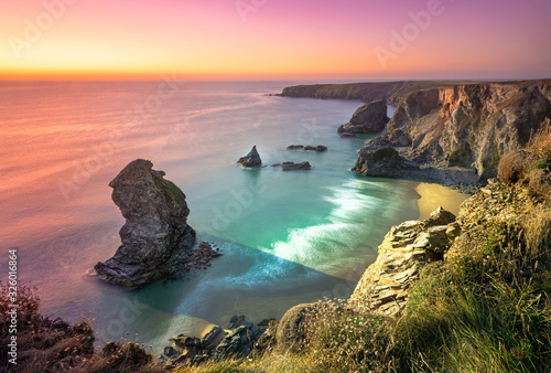 Sunset at Bedruthan Steps. Carnewas and Bedruthan Steps is a stretch of coastline located on the north Cornish coast between Padstow and Newquay, in Cornwall, England, United Kingdom photo