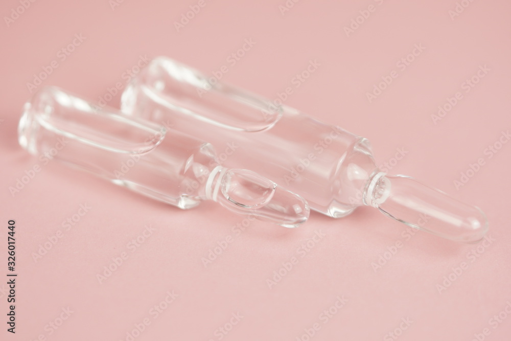 Glass medical ampoules on a pink background close-up, copy space,selective focus,macro photo. Glass medical ampoules on a pink background close-up, copy space,selective focus,macro photo.
