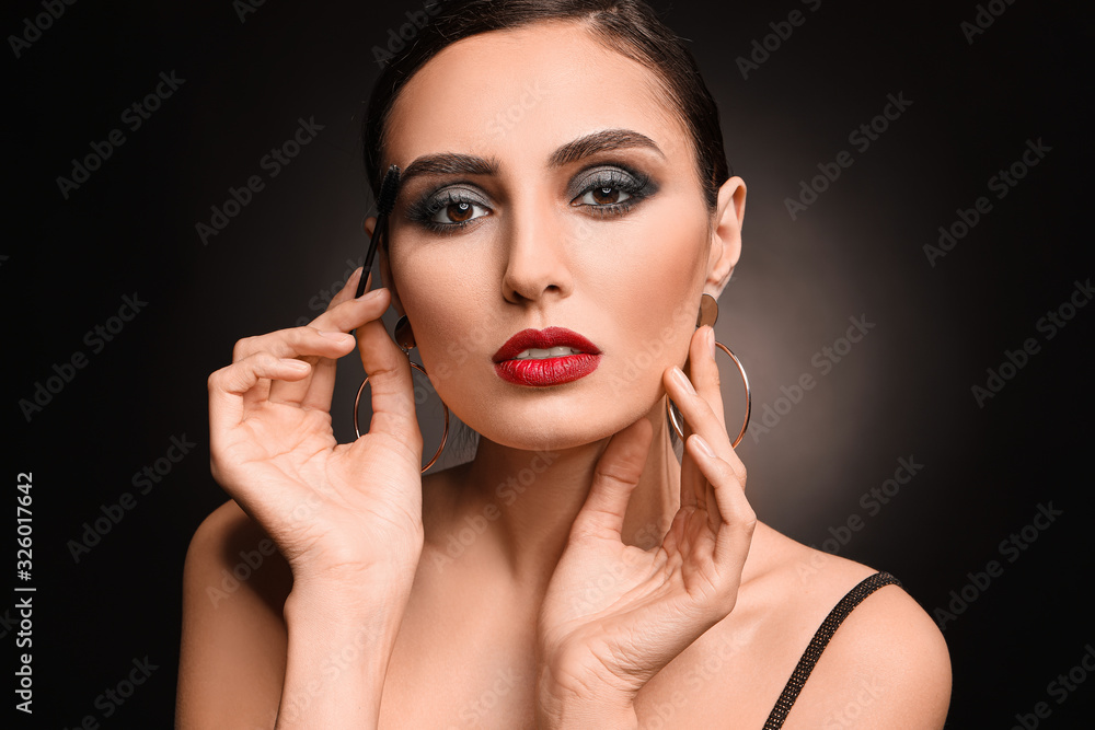 Young woman with beautiful makeup on dark background Young woman with beautiful makeup on dark background