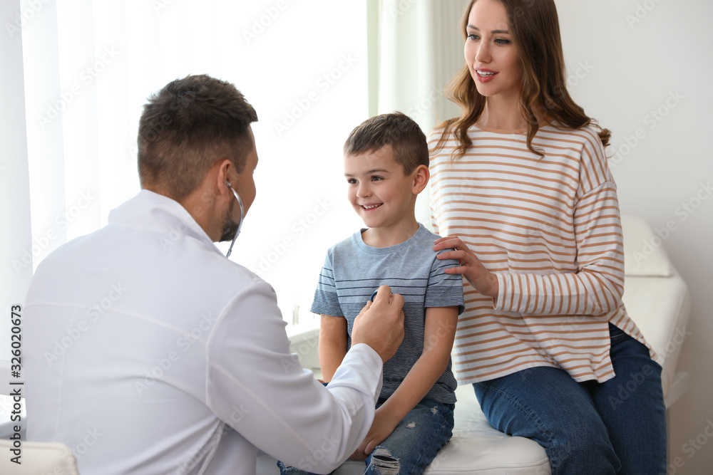 Mother and son visiting pediatrician. Doctor examining little patient with stethoscope in hospital Mother and son visiting pediatrician. Doctor examining little patient with stethoscope in hospital