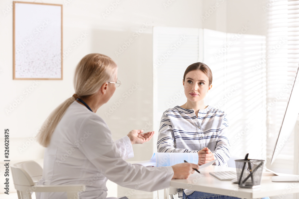 Doctor consulting patient at desk in clinic Doctor consulting patient at desk in clinic