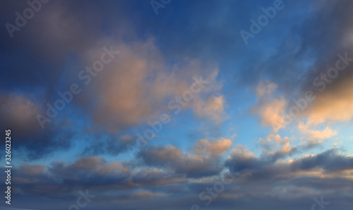 Fototapeta Naklejka Na Ścianę i Meble -  Dark clouds lit by the evening sun with gleams of blue sky.