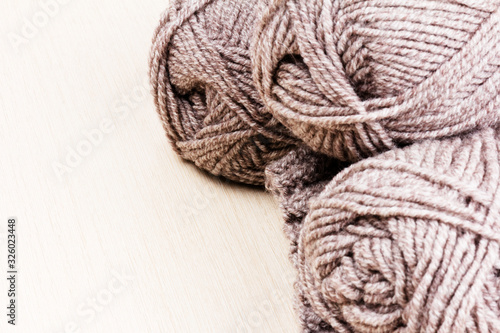 woolen threads on wooden background. natural wool knitting background