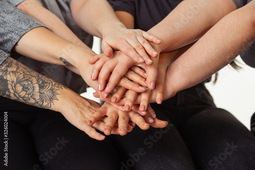 Close up of hands of young caucasian women in casual clothes. Friends sitting near by window and laughting, spending time together. Bodypositive, nutrition, feminism, loving themself, beauty concept.