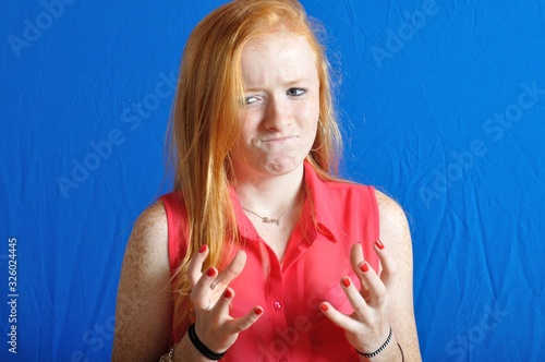фотографія Irritated teen on blue background