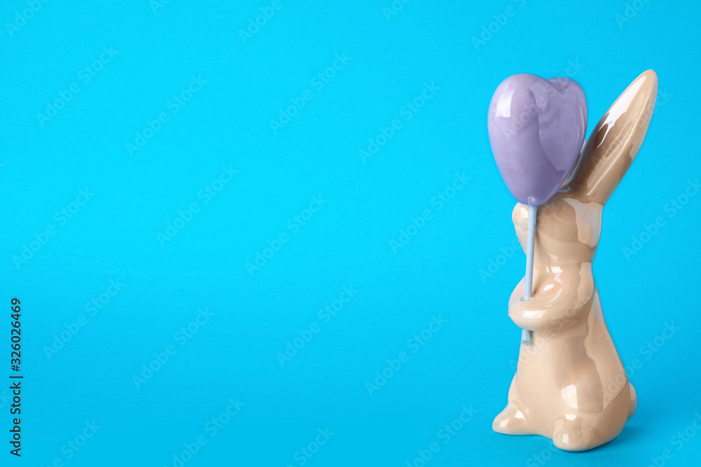Bunny ceramic figure as Easter decor on blue background. Space for text Bunny ceramic figure as Easter decor on blue background. Space for text