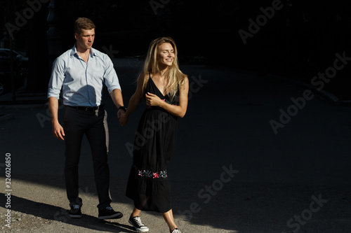 happy couple, man and woman, over black background. hold hands, go and smile