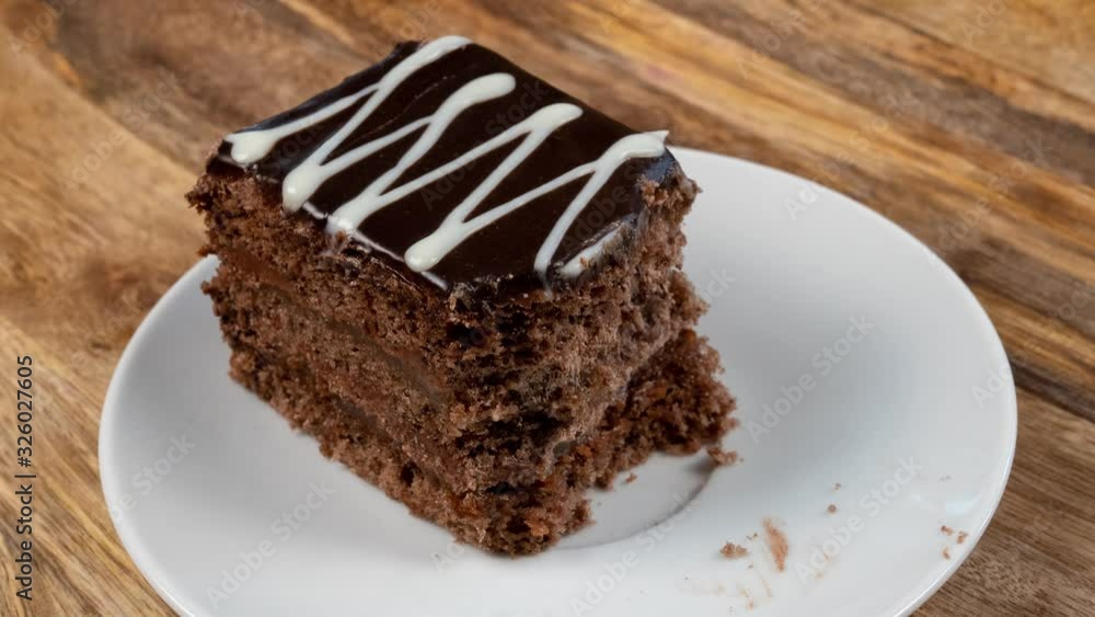 The Reverse Process of Eating a Chocolate Cake on a White Platter is a Stop Motion. Restoration Of The Eaten Cake The Reverse Process of Eating a Chocolate Cake on a White Platter is a Stop Motion. Restoration Of The Eaten Cake